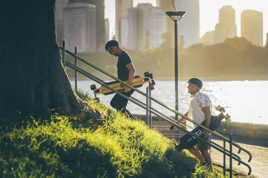 Riders portant leur skate électrique Evolve dans les escaliers en ville